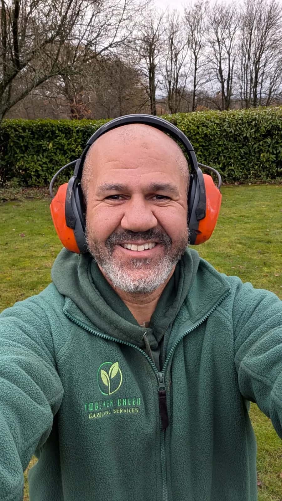 Glen Kirby, owner of Together Green Gardening Services, in his green work fleece with ear defenders